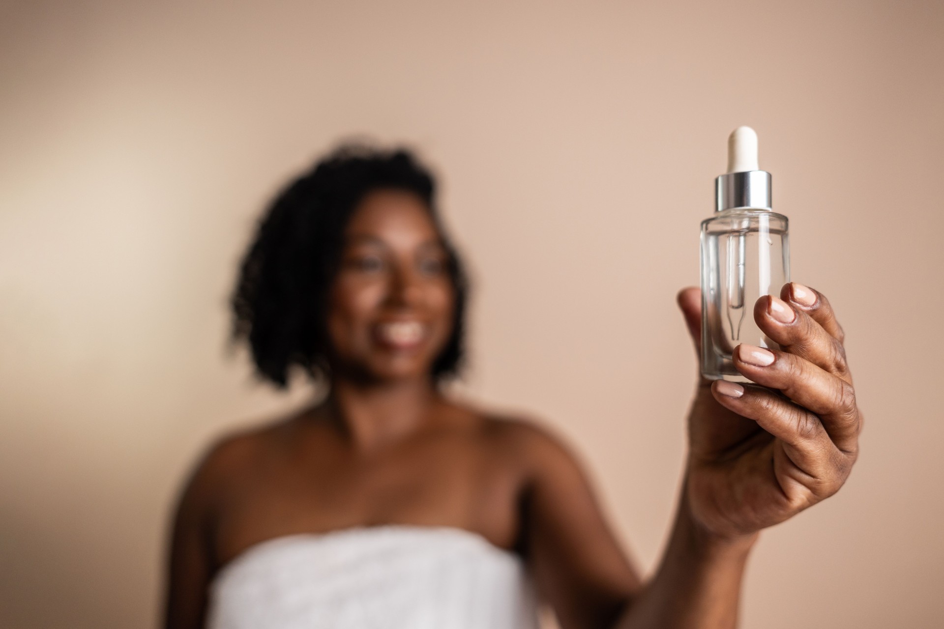 Close-up of a woman holding a face serum