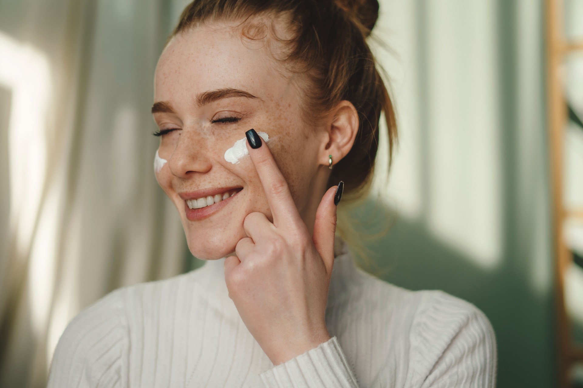 Smiling woman applying eye patches