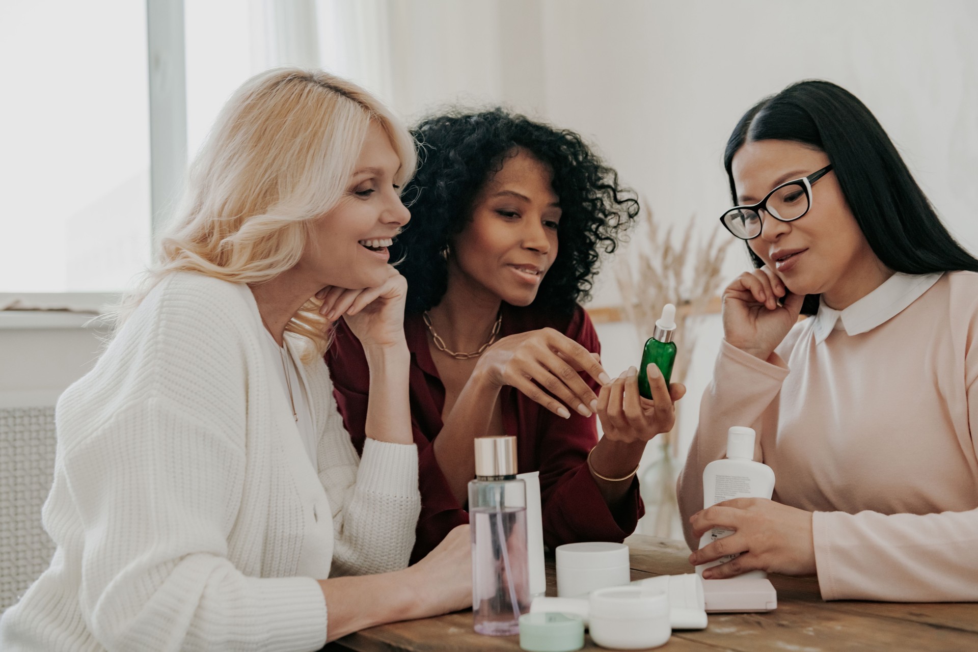 Three mature women examining beauty treatments while sitting at the desk together